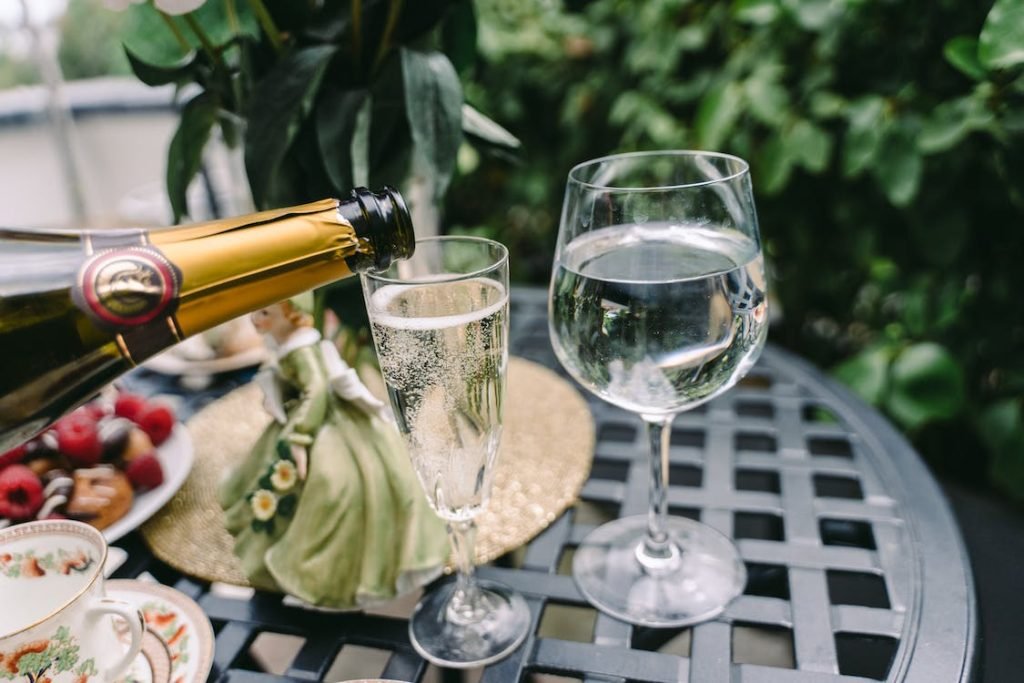 Pouring  sparkling white wine into a flute glass, with a brunch setting in the background, capturing the essence of a refined dining experience.