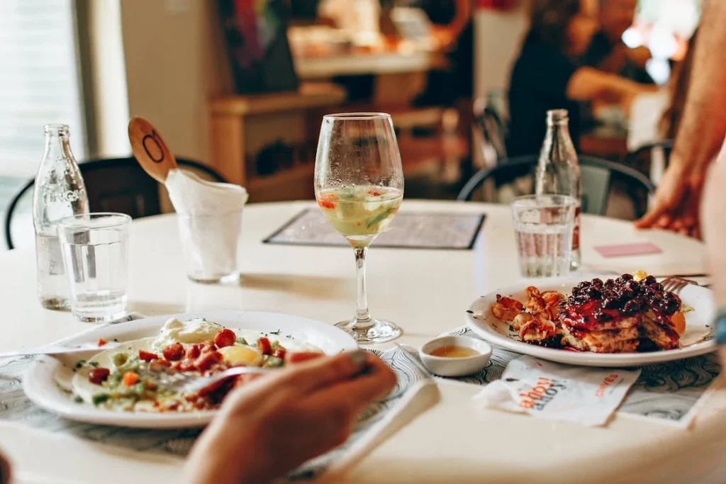 A table adorned with a variety of brunch dishes, including a glass of white sangria, complements the meal and invites a toast to leisurely weekend mornings.
