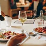 A table adorned with a variety of brunch dishes, including a glass of white sangria, complements the meal and invites a toast to leisurely weekend mornings.